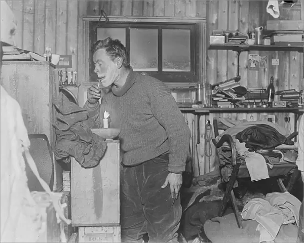 George Murray Levick shaves by candlelight in the hut