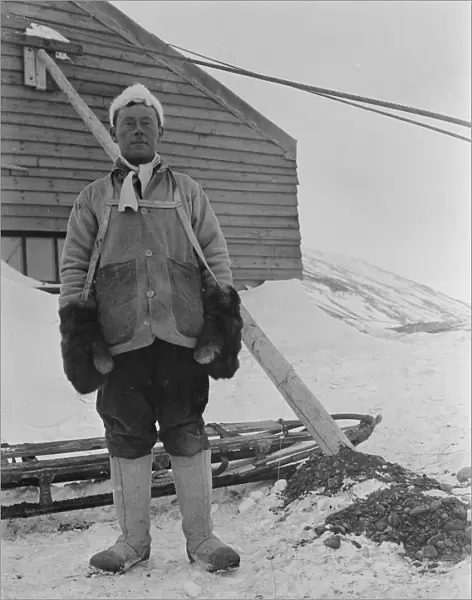 Portrait of George Murray Levick beside a sledge and hut