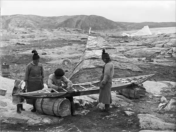 Inuit sewing skin on kayak