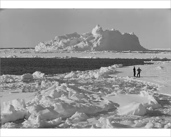 Iceberg in pack ice. Tryggve Gran and Thomas McLeod on ice. December 20th 1910