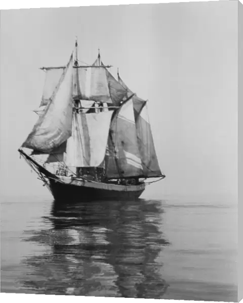 Penola at sea with sails set, reflections in foreground