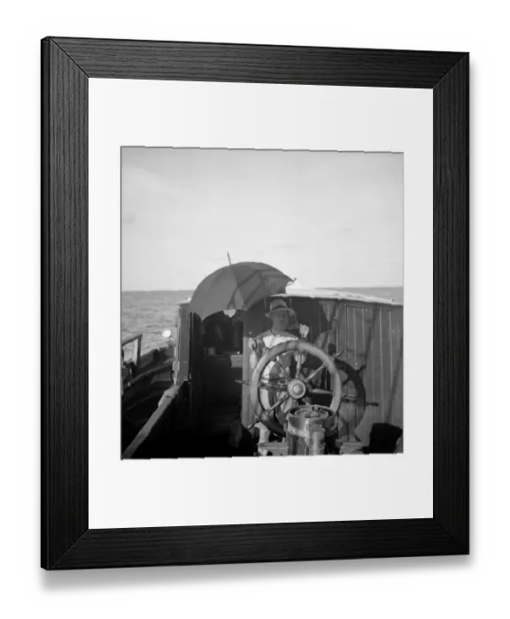 Framed Print : Quintin Riley at helm under umbrella Framed Print : Quintin Riley at helm under umbrella