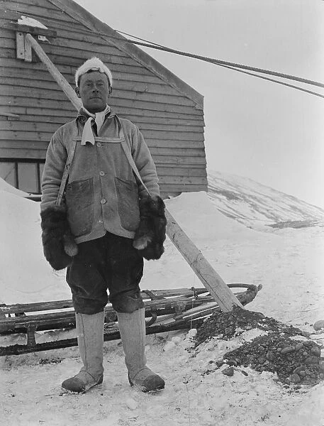 Portrait of George Murray Levick beside a sledge and hut