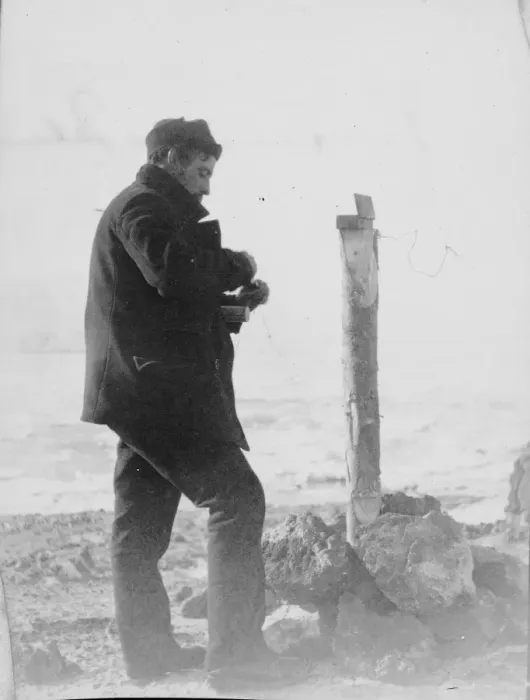 Framed Print : Post office, Possession Island. A man places contents inside a canister Framed Print : Post office, Possession Island. A man places contents inside a canister