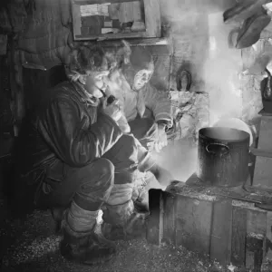 Cecil Meares and Capt Oates at the blubber stove, cooking food for the dogs. May 26th 1911