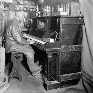 Cecil Meares at the pianola in the Winterquarters Hut. January 1912