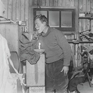 George Murray Levick shaves by candlelight in the hut