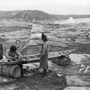 Inuit sewing skin on kayak