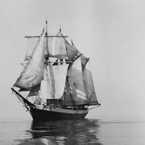 Penola at sea with sails set, reflections in foreground