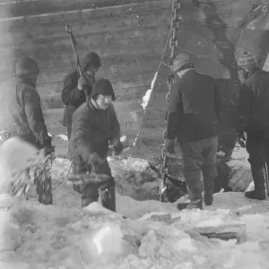 Trying to cut the anchor free from the ice