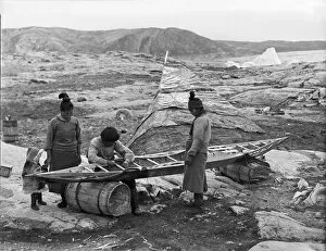 Inuit sewing skin on kayak